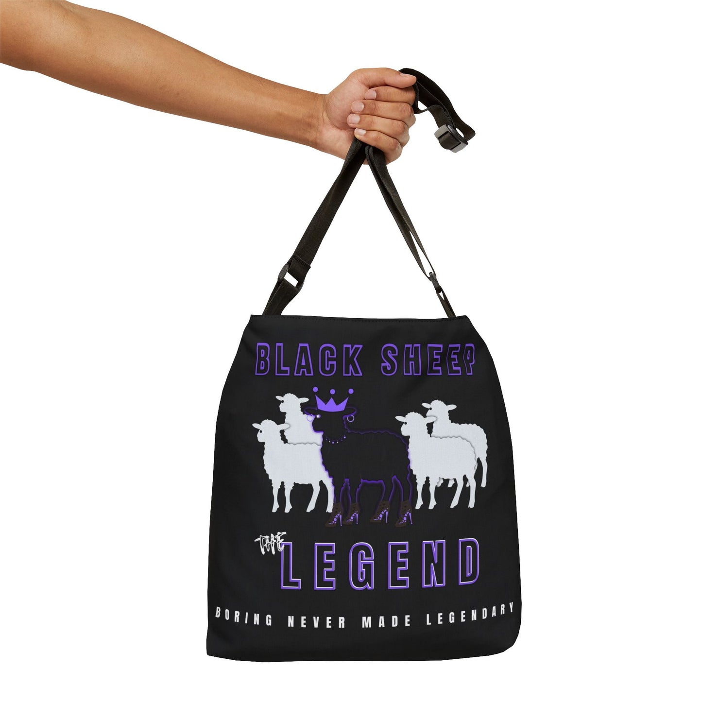 Black tote bag with white sheep graphic and purple text held by a hand on a white background